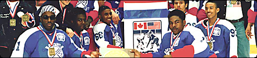 Photo of the Detroit Rockies celebrating their victory in Lake Placid, NY at the Can/AM Challenge Cup tournament.  The Rockies were the first, all-black (African American) hockey team to compete and win at the Midget AA level.
